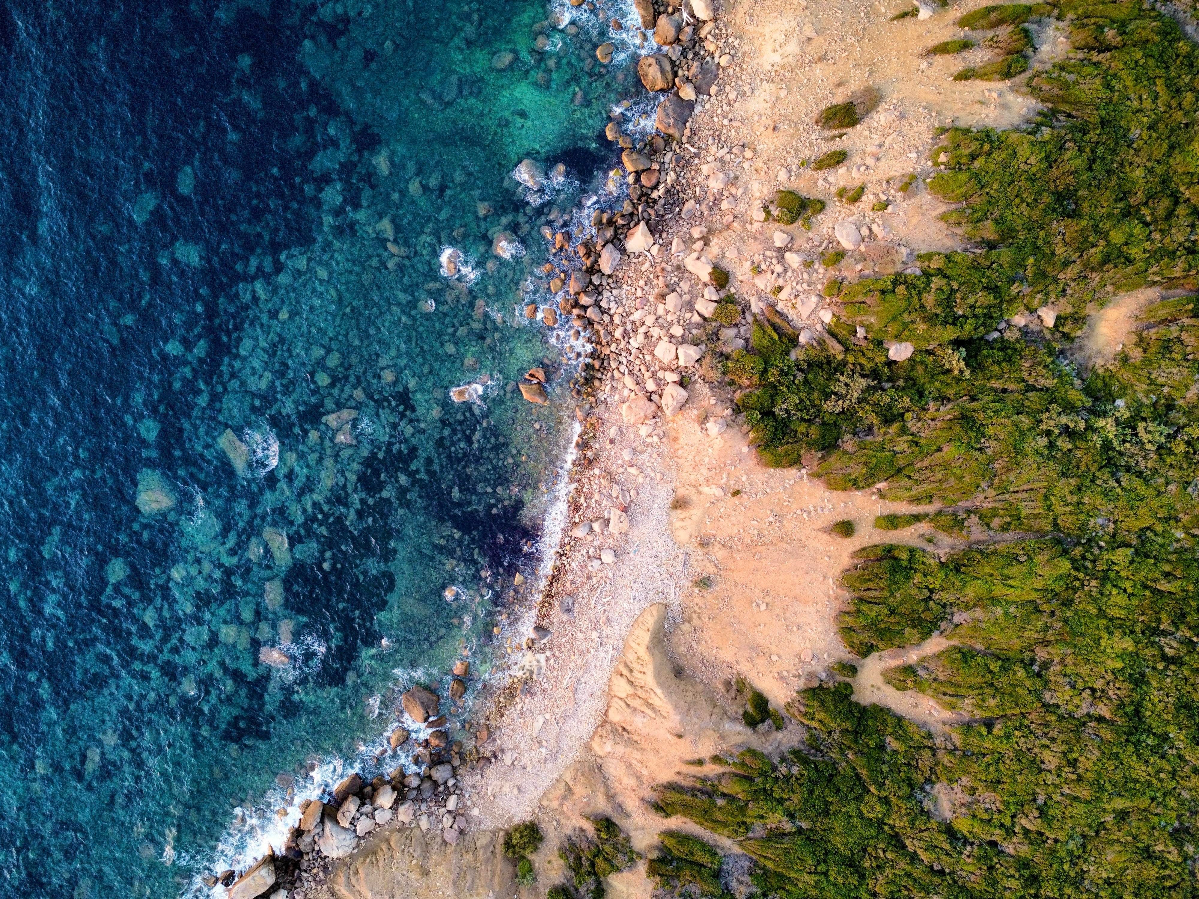 Breathtaking aerial view of the Béja coastline, showcasing lush greenery and turquoise waters.