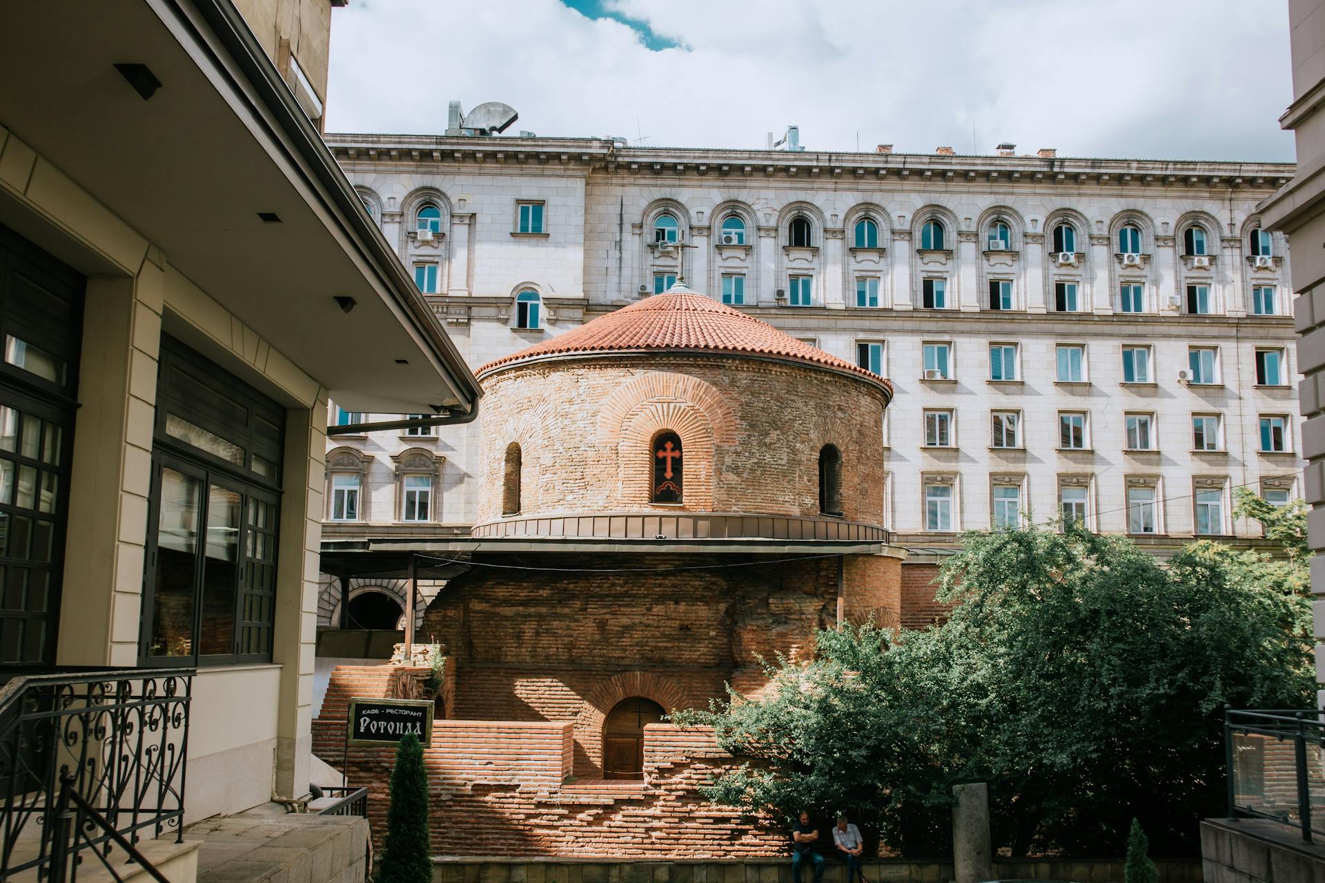 The ancient Rotunda of St. George in Sofia, Bulgaria, with modern backdrop.
