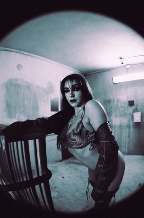 Free Artistic portrait of a woman in a dimly lit urban setting with a retro vibe. Stock Photo