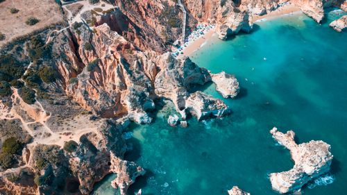 Free Stunning aerial view of Algarve's rocky coastline and turquoise waters. Stock Photo
