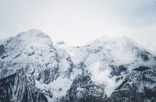 Free Stunning view of towering snow-capped mountains with misty clouds. Stock Photo