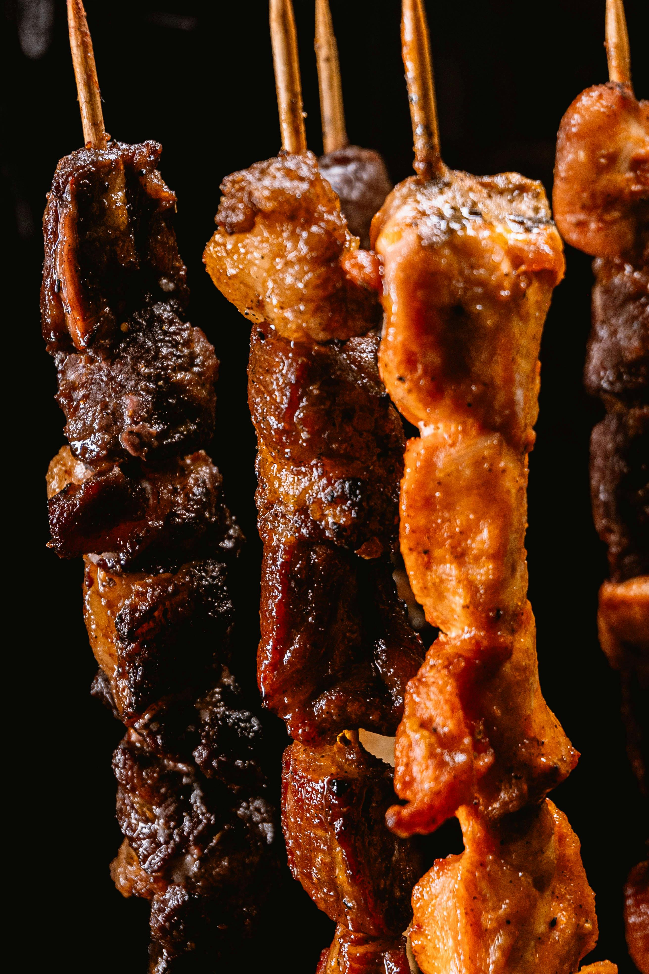 delicious grilled meat skewers on dark background