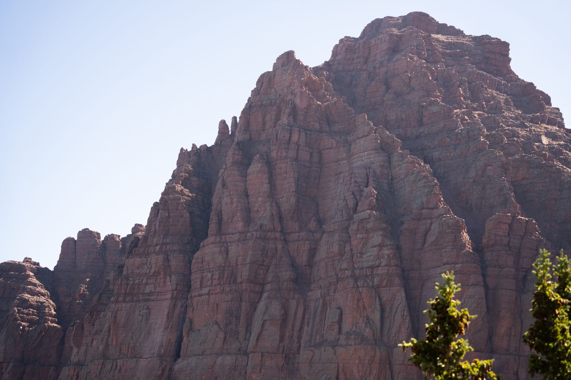 Impressive red rock cliffs under a clear blue sky in Utah's Uinta Mountains.