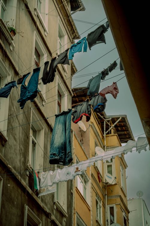 Free Vibrant clothing hanging on lines between buildings in a rustic urban alleyway, showcasing everyday life. Stock Photo