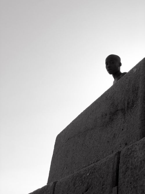Free A minimalist black and white portrait of a person behind concrete walls in Tanzania. Stock Photo