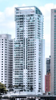 Tall modern skyscraper among high-rise buildings in city skyline