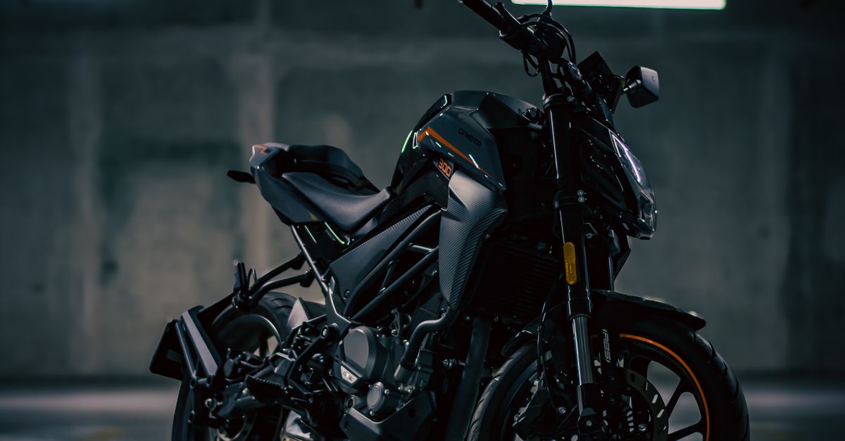 Sleek black motorcycle standing in dim garage lighting · Free Stock Photo