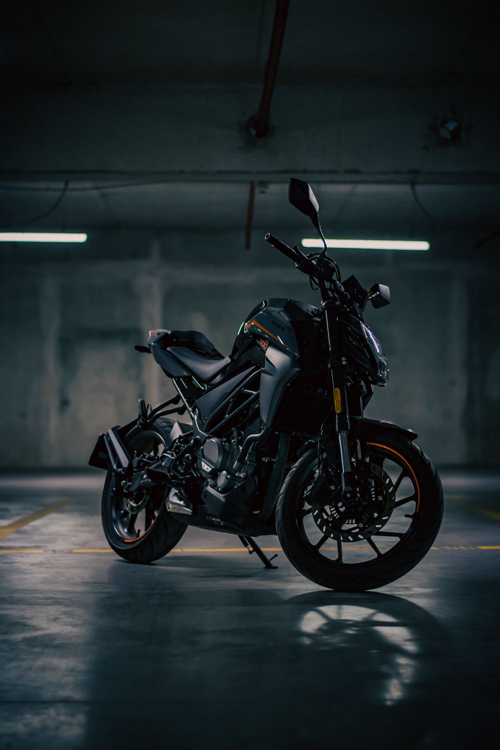 Sleek black motorcycle standing in dim garage lighting · Free Stock Photo