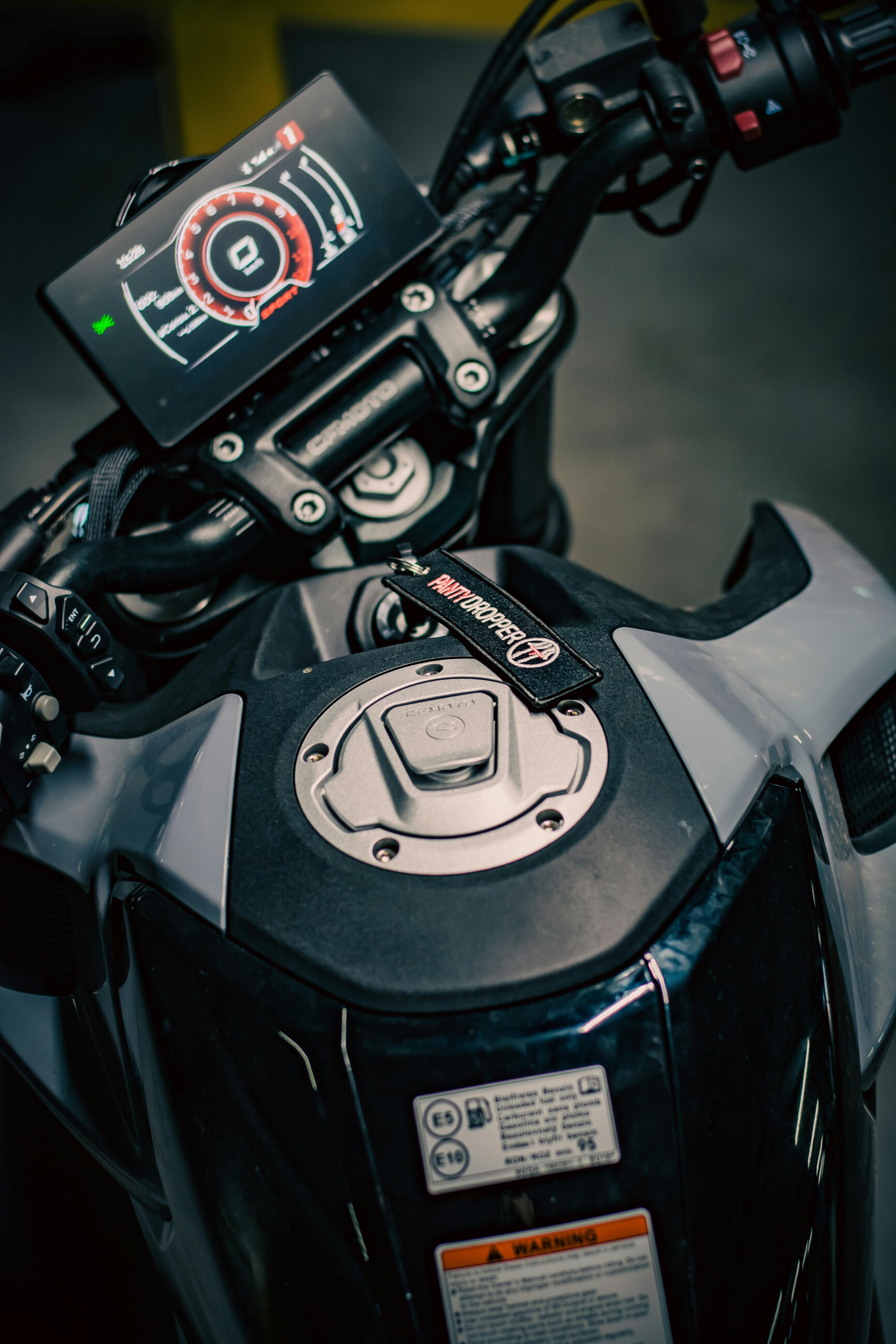 Detailed close-up image of a motorcycle dashboard and fuel tank in a modern design.
