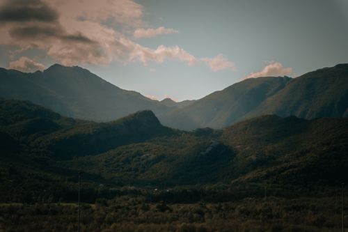 Free A peaceful view of mountains with lush greenery under a cloudy sky, evoking tranquility. Stock Photo