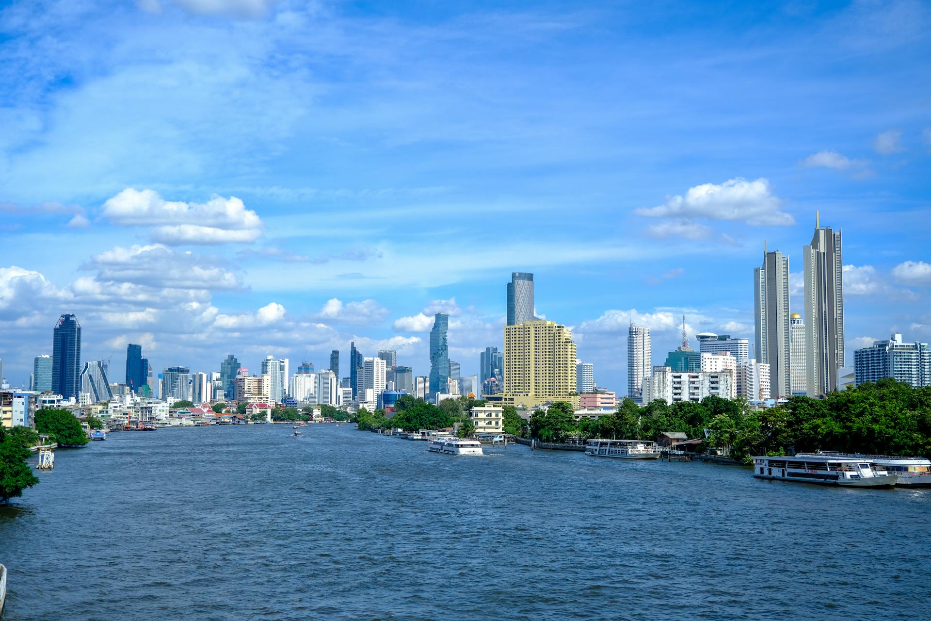 Vibrant Bangkok city skyline with Chao Phraya River, showcasing a mix of modern architecture and nature.