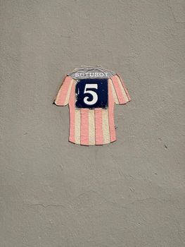 Retro wall art featuring a striped jersey with number 5 on a textured surface.