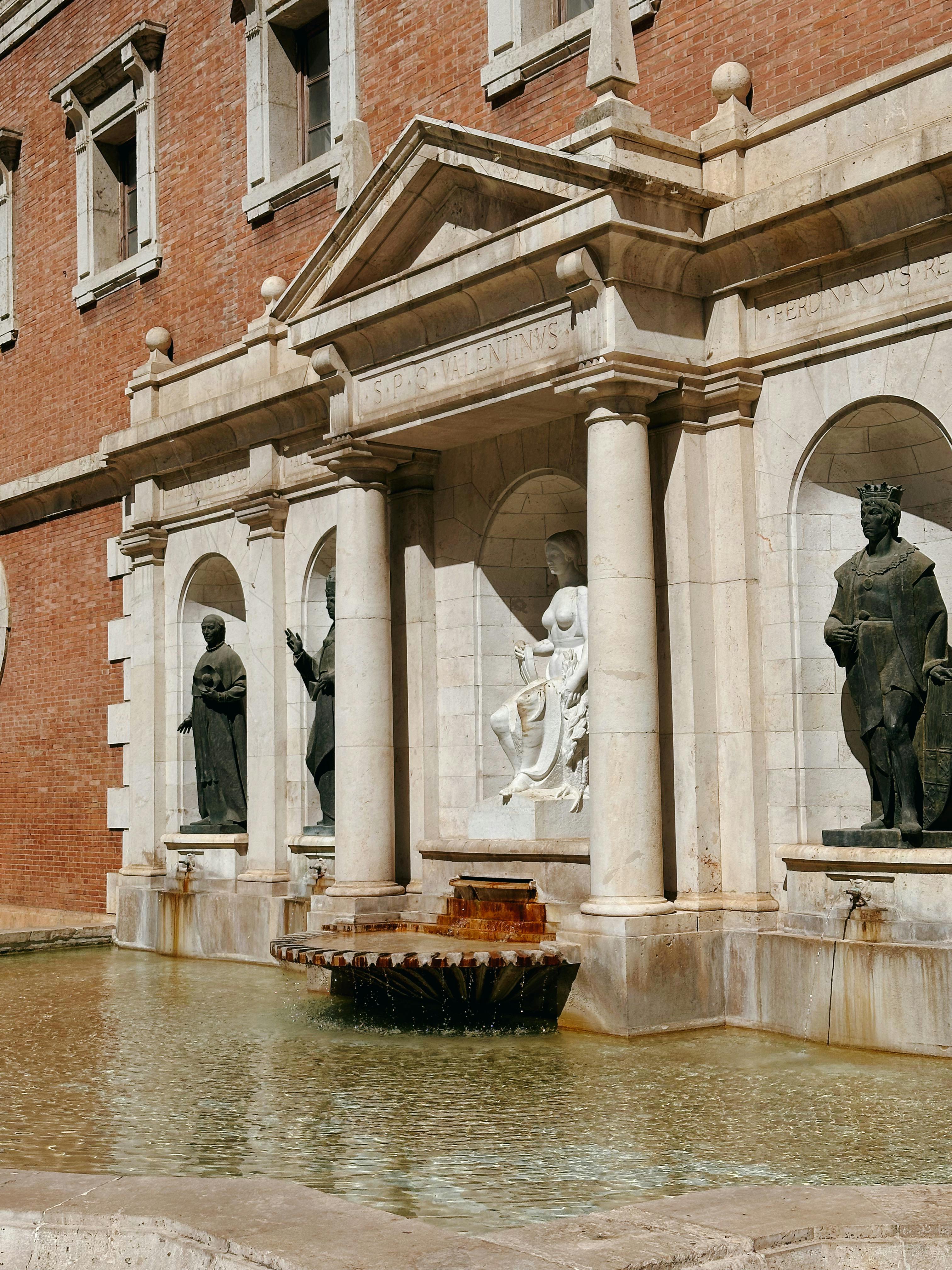 classical stone statues on historic fountain