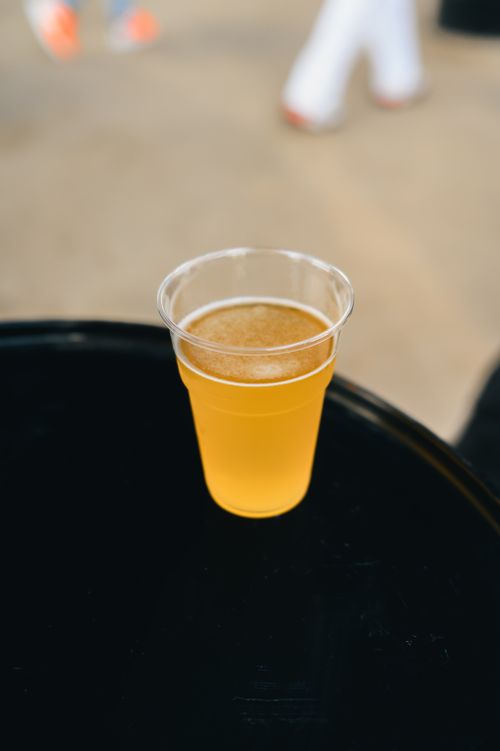 Free A foamy beer in a clear plastic cup on a black table, perfect for parties. Stock Photo