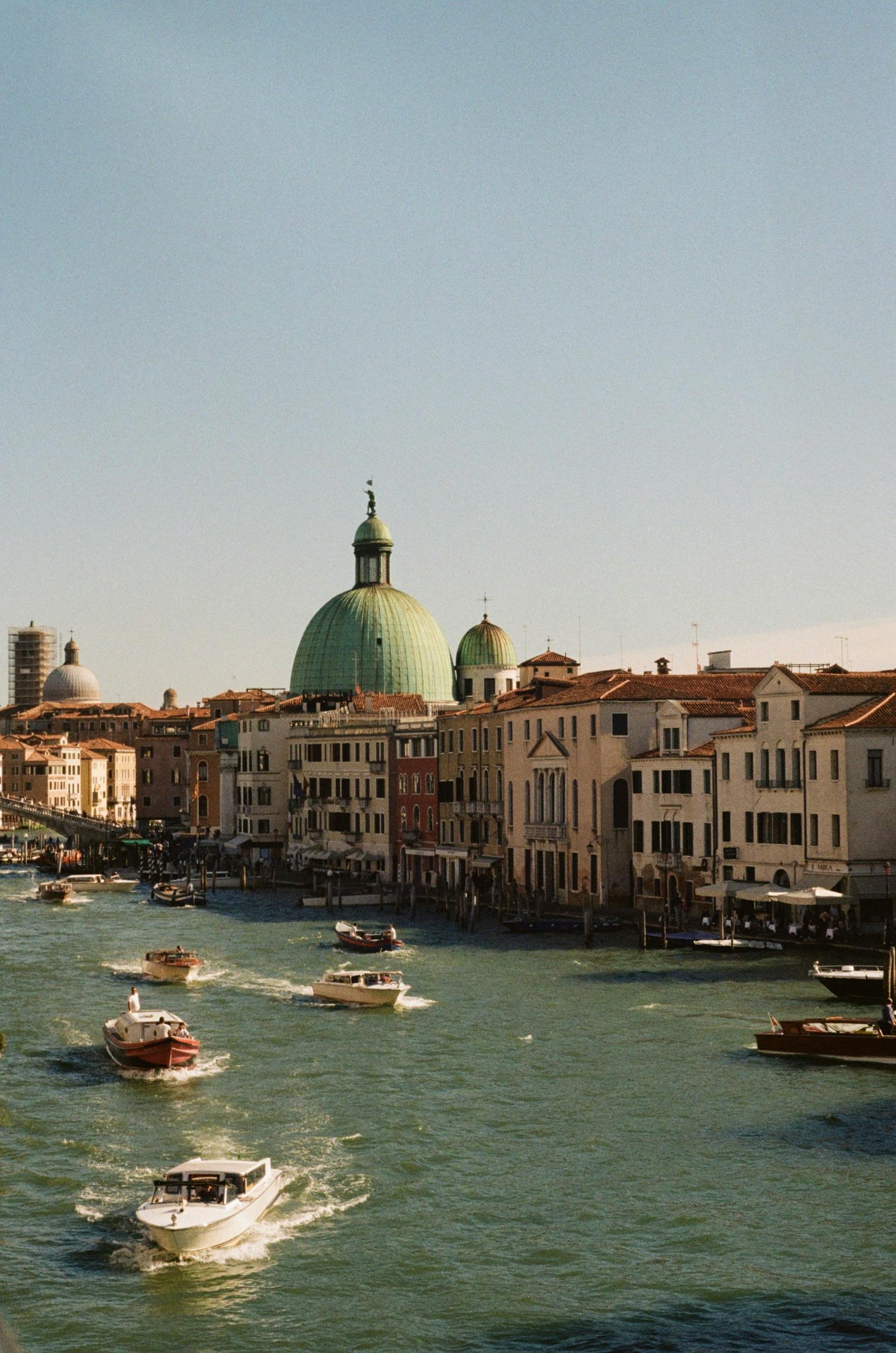 Explore the historic Venice canal with iconic architecture and vibrant boat traffic.