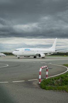 A commercial airplane on the runway at Wrocław Airport, under cloudy skies.