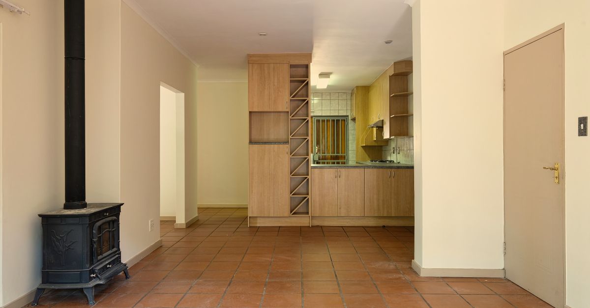 Spacious living area with a modern kitchen, warm tones, and a wood-burning stove.