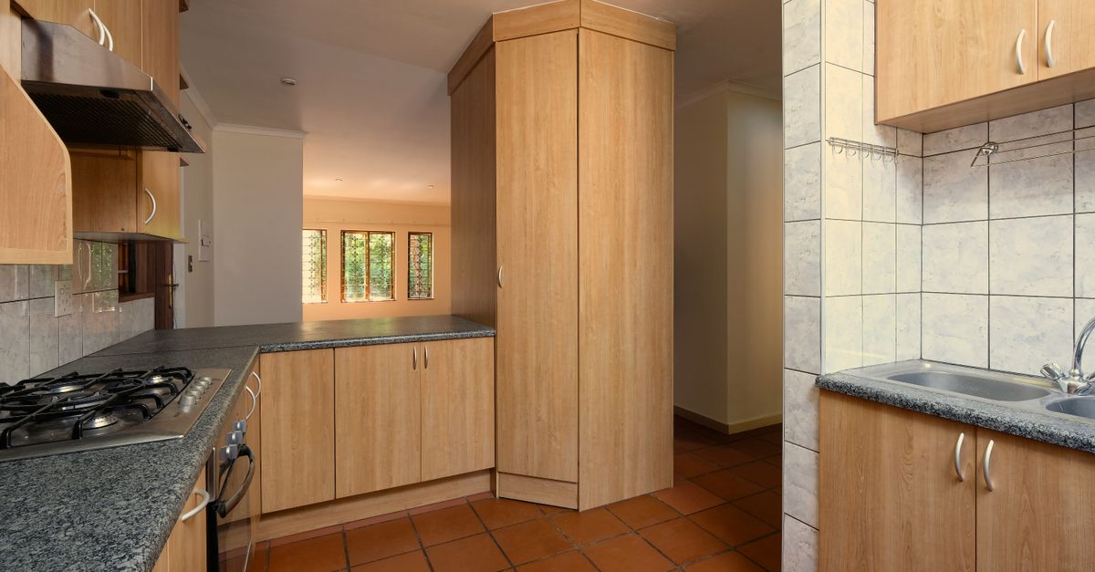 Spacious and modern kitchen featuring wooden cabinetry and natural light streaming through windows.