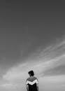 Contemplative Man Under Vast Sky in Black and White