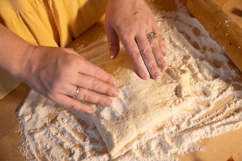 Free Close-up of hands kneading dough on a wooden surface with flour. Stock Photo