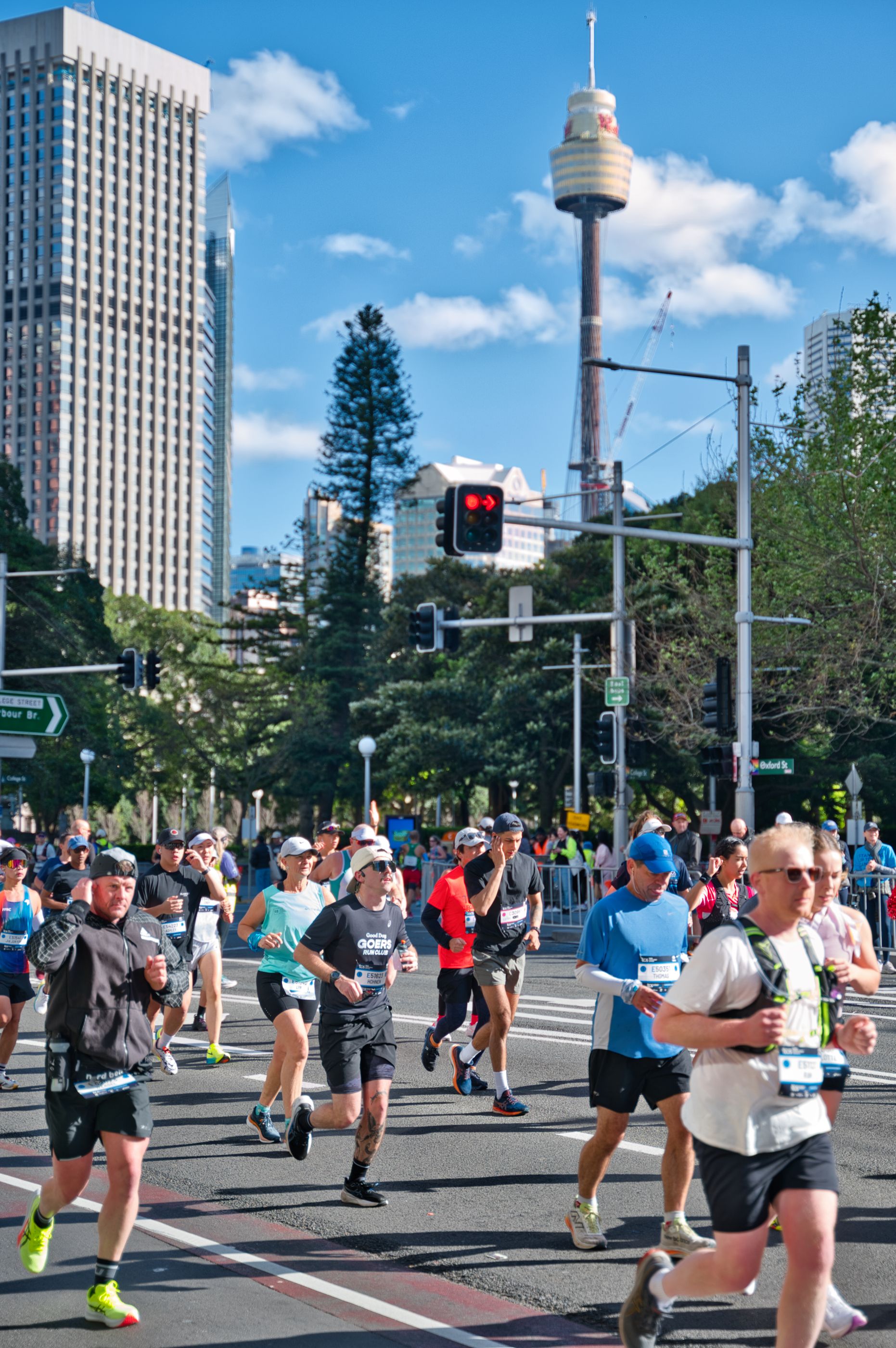 A vibrant city marathon scene with runners in Sydney, Australia near a renowned landmark.