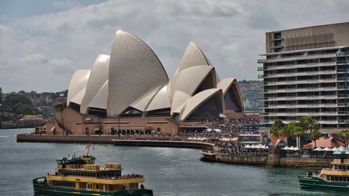 Free A vibrant scene at Sydney Opera House with a ferry passing by, showcasing Sydney's lively waterfront. Stock Photo