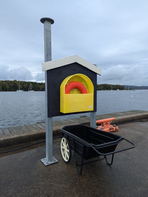 Free Bright lifebuoy in a yellow case on a Halifax dock, ready for emergencies. Stock Photo