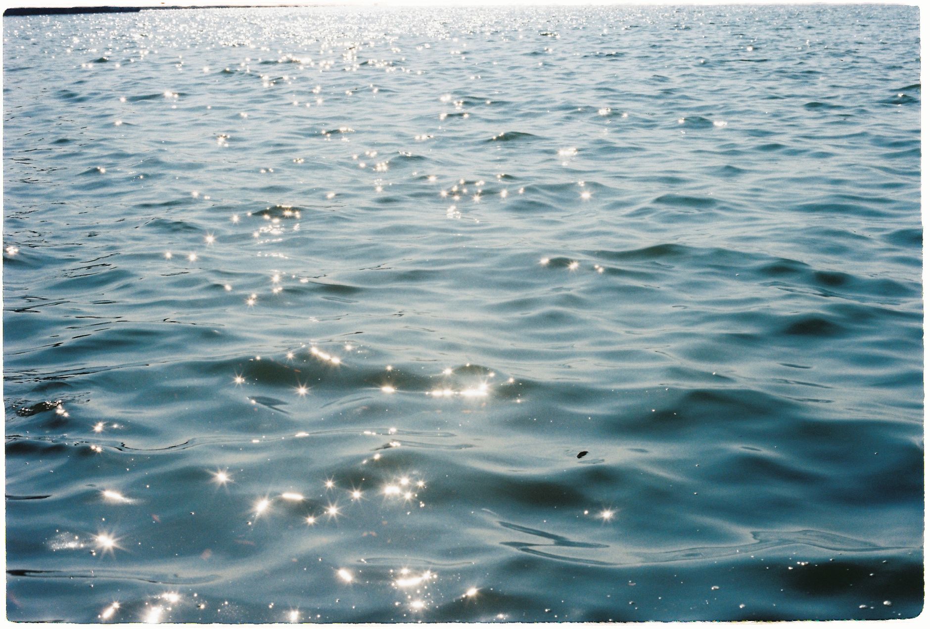 Sunlit water surface creating sparkling reflections on a sunny day.