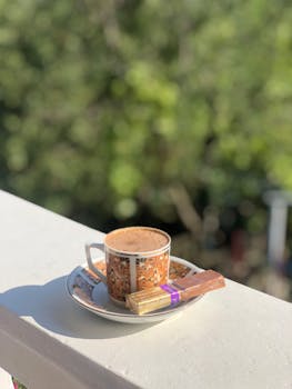 A warm cup of coffee with chocolates on a sunny balcony, perfect morning.