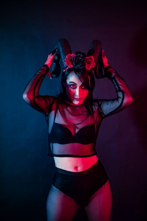 Free Artistic portrait of a woman wearing horns in dramatic lighting, expressing dark fantasy. Stock Photo