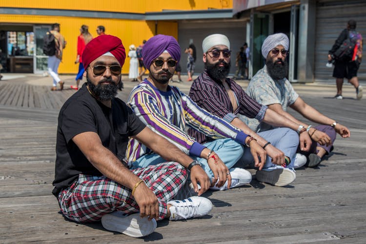 Indian Men In Turbans Sitting On Wooden Surface Posing 