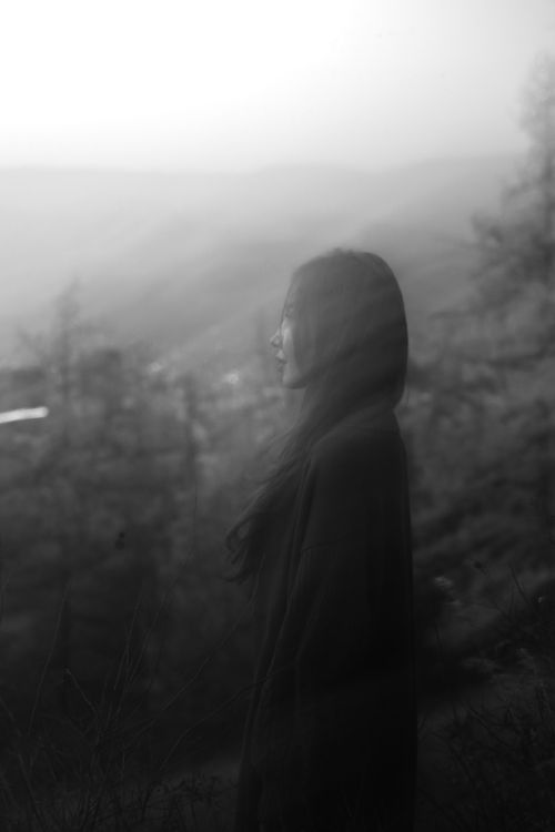 Free A contemplative silhouette of a woman in a foggy, mystical landscape, evokes introspection. Stock Photo