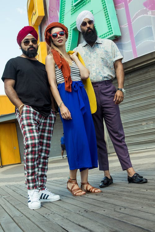 Photo of Woman Standing in Between Two Indian Men with Turbans
