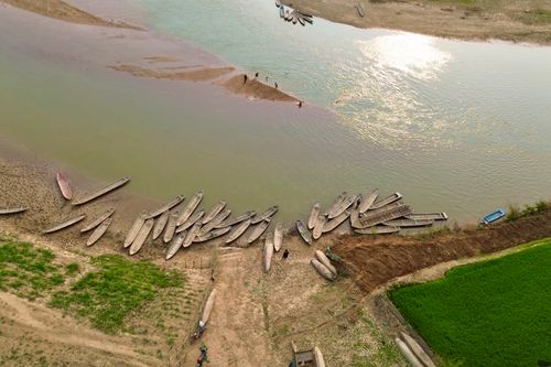 Free Aerial view of wooden boats on a tranquil riverbank with greenery. Stock Photo