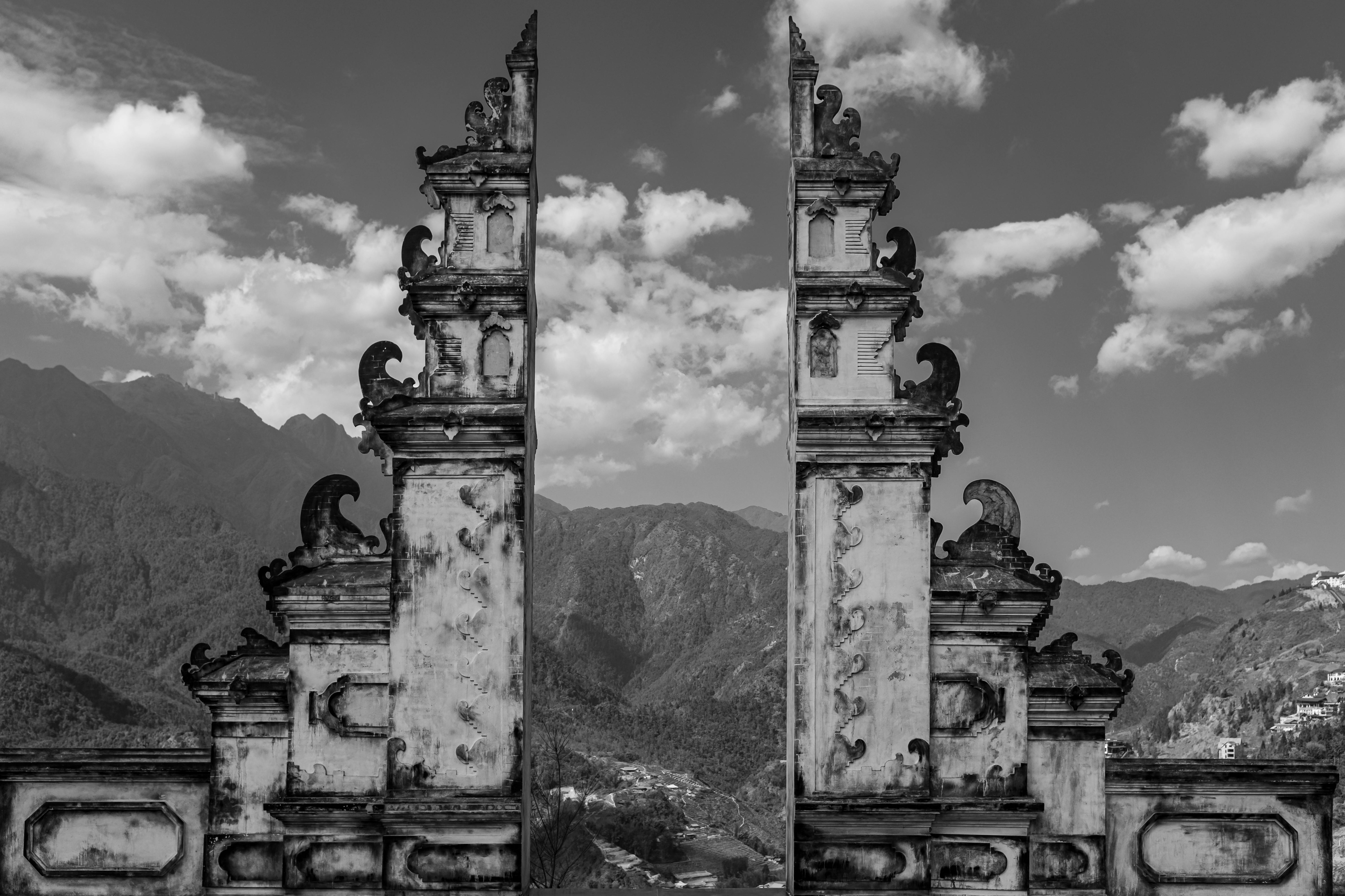 Black and white photo of a traditional gate with mountain scenery in Lao Cai, Vietnam.