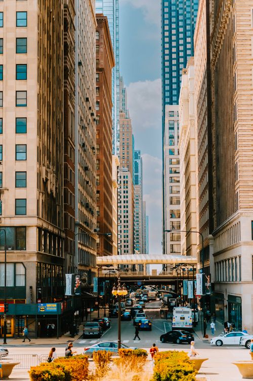 Free Bustling city street between tall buildings, daytime urban life. Stock Photo