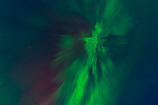 Vibrant aurora borealis illuminating the starry night sky with green hues and cosmic energy.