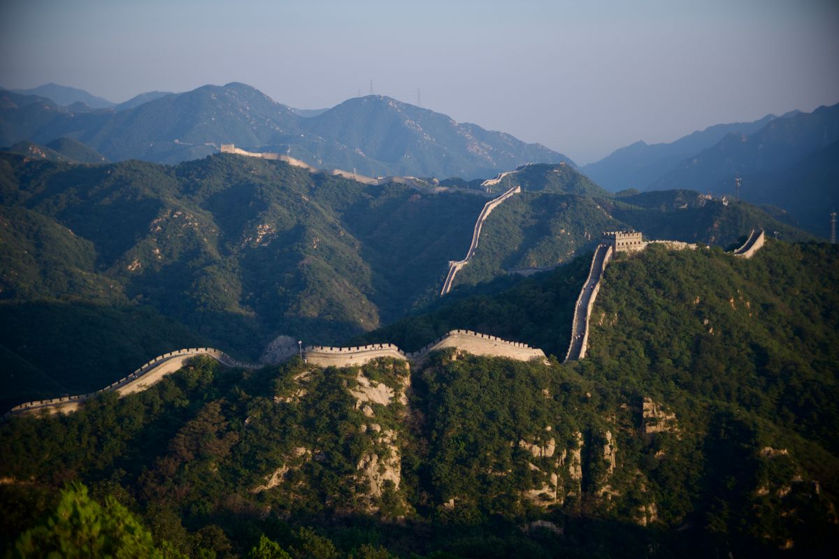 Scenic view of the Great Wall of China stretching over lush forested mountains near Mutianyu