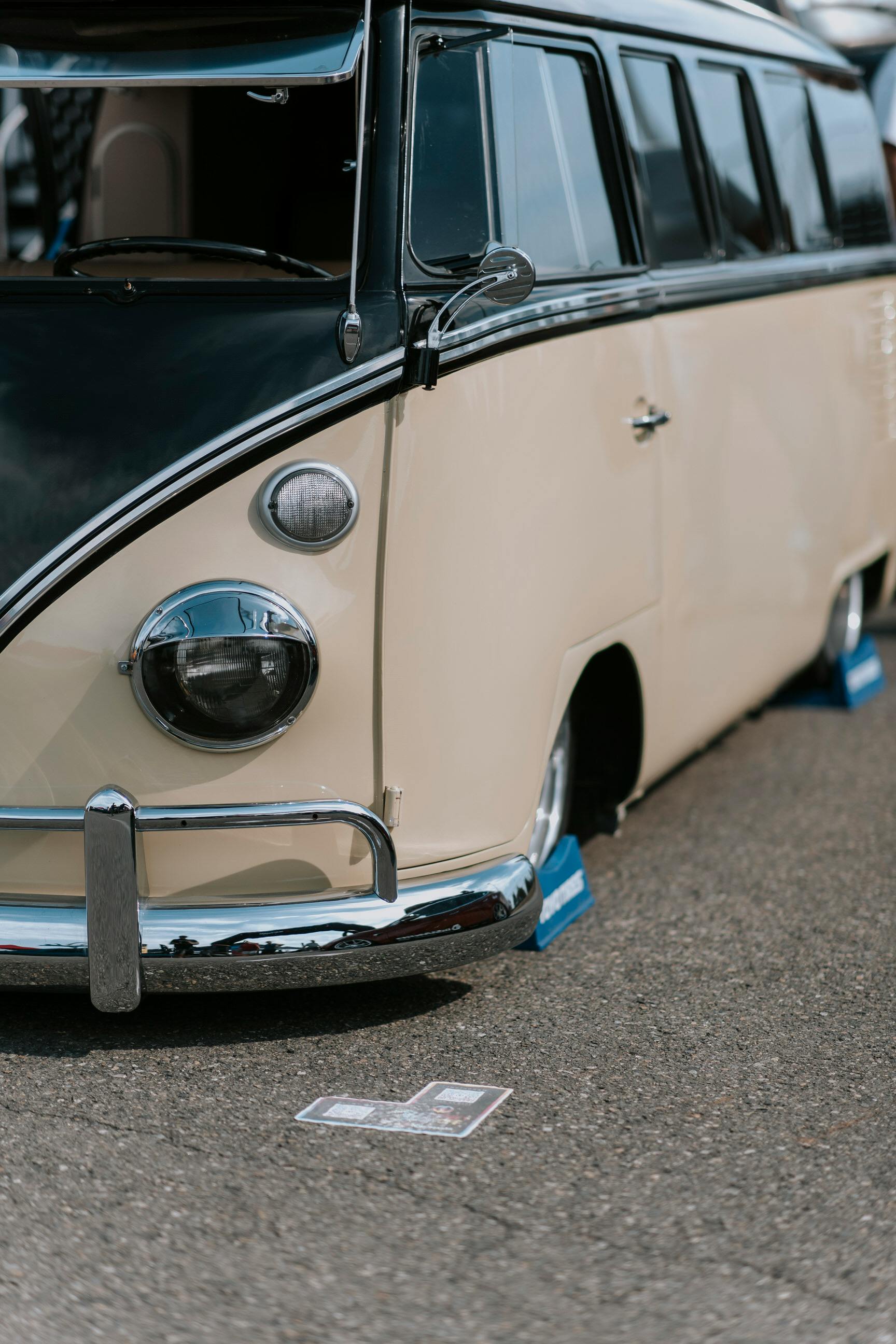 Close-up of a classic cream and black camper van showcased outdoors.