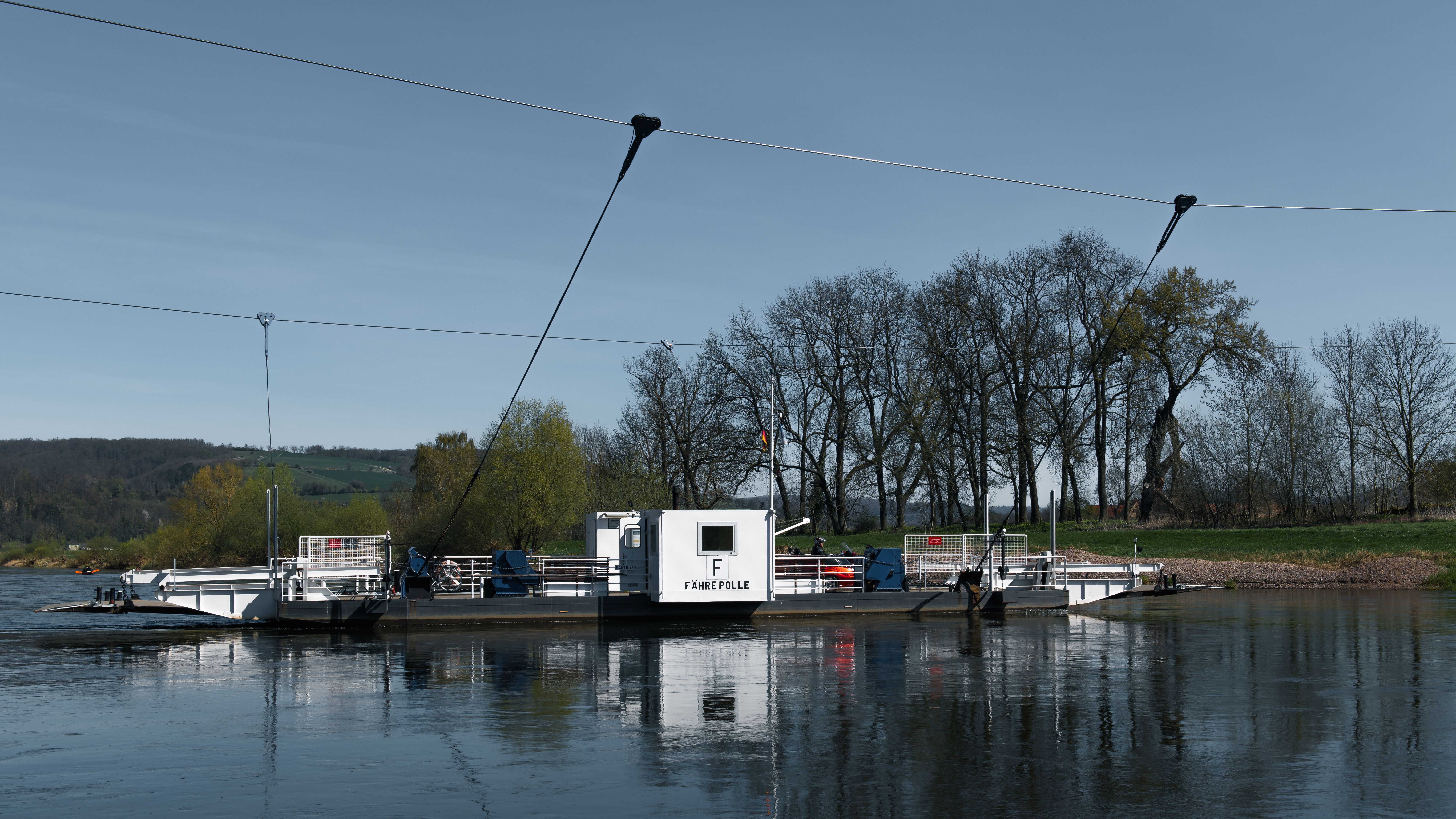 Idyllic view of a ferry crossing the Weser River near Holzminden, Germany.