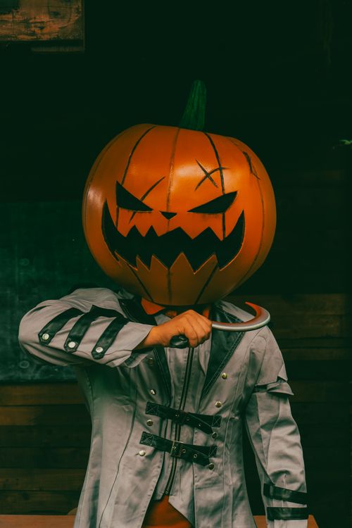 Free Spooky Halloween figure with a pumpkin head and knife, perfect for October scenes. Stock Photo