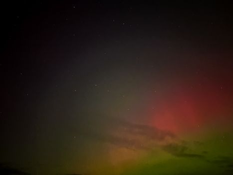 Capture of a mesmerizing night sky with faint aurora borealis glow and scattered stars.
