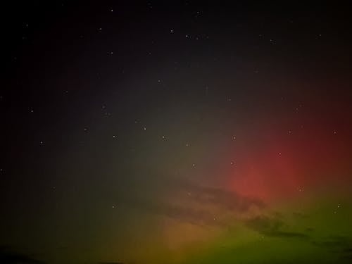 Free Capture of a mesmerizing night sky with faint aurora borealis glow and scattered stars. Stock Photo