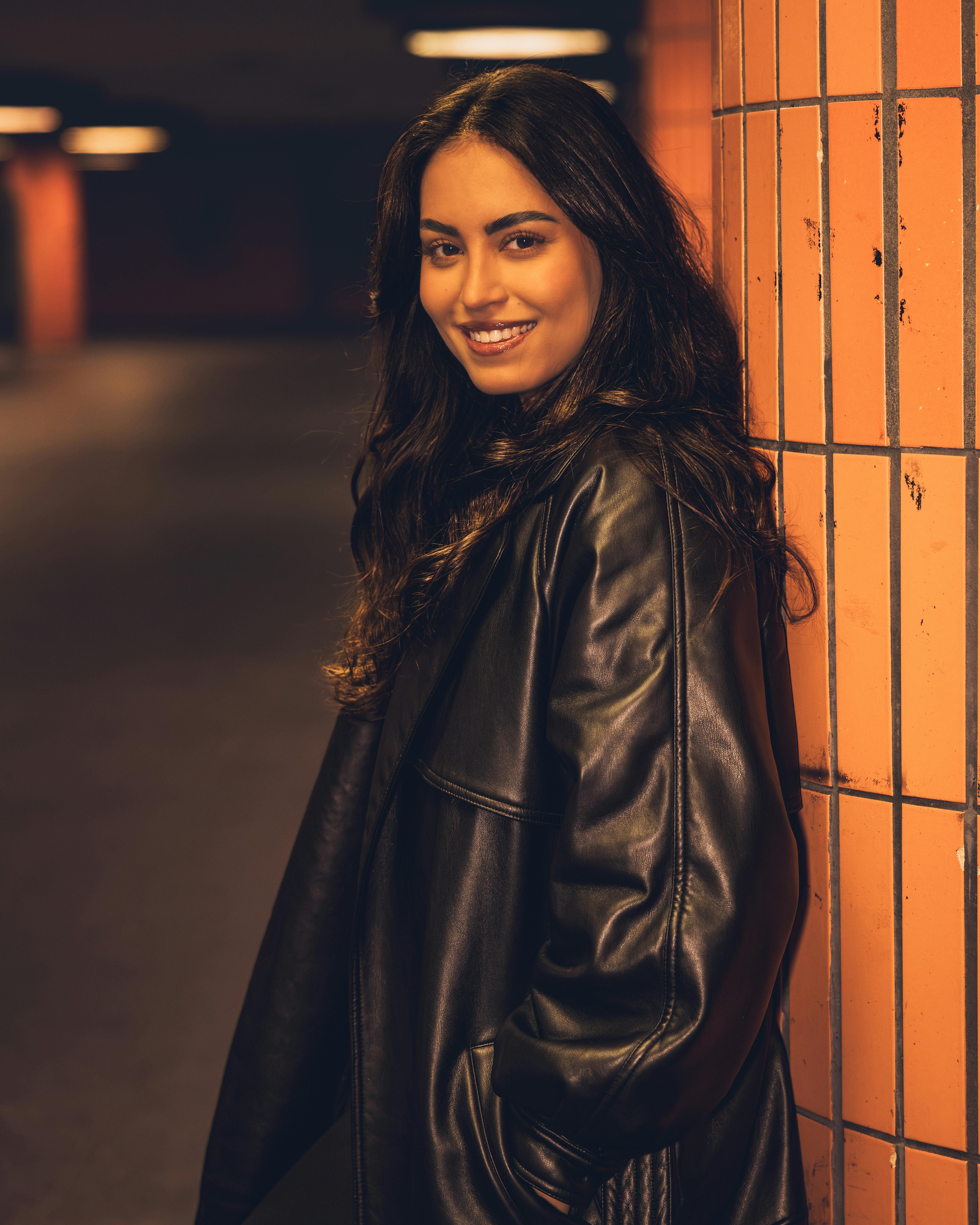 young woman smiling in urban setting at night