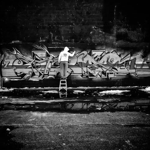 Grayscale Photo of Person Doing Graffiti