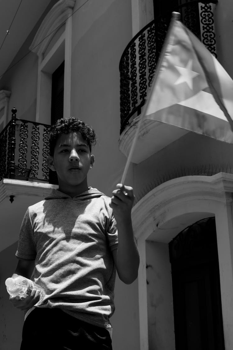 Grayscale Photo Of Teenage Boy Holding Cuban Flag