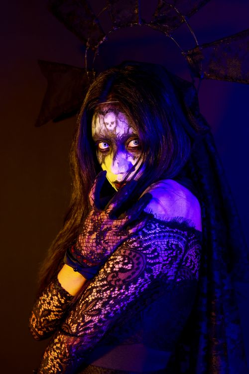 Free Image of a woman with intricate face paint, captivating gaze, in a mystical atmosphere. Stock Photo