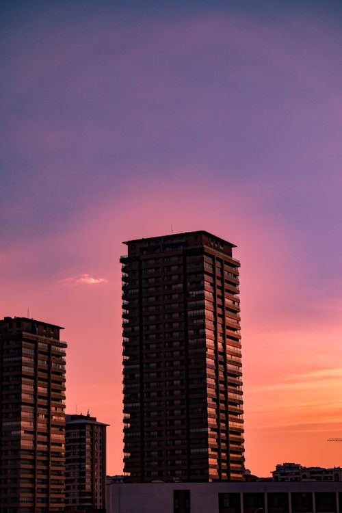 Free Silhouetted high-rise buildings against a vibrant sunset sky. Stock Photo