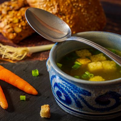 A blue bowl of vegetable broth