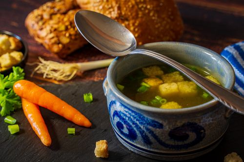 Free Delicious vegetable broth with croutons served in a blue bowl, perfect for a comforting winter meal. Stock Photo
